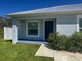 Sebring house for rent - A living room with a couch, a coffee table, and a potted plant.