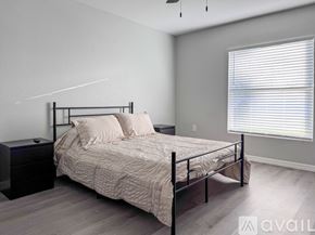 Sebring house for rent - A bedroom with a bed, nightstand, and window with blinds.