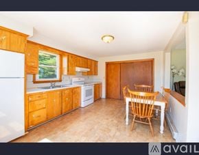 Lisbon townhouse for rent - A kitchen with wooden cabinets and a dining table.
