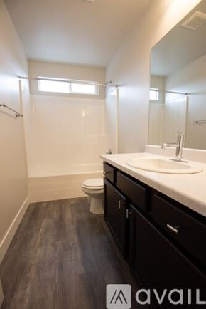Lehi apartment for rent - A bathroom with a toilet, sink, and mirror.