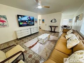 Miami Beach apartment for rent - A living room with a flat screen TV mounted on the wall.