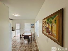 Miami Beach apartment for rent - A dining room with a table and chairs and a painting on the wall.