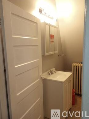 Chicago apartment for rent - A small white bathroom with a sink and a radiator.