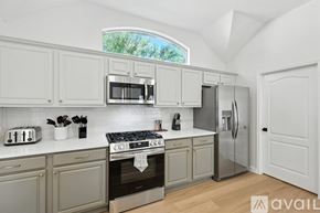 Frisco house for rent - A kitchen with white cabinets and a stove top oven.