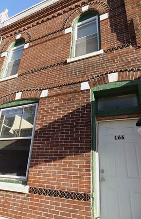 Philadelphia apartment for rent - A red brick building with a white door and windows.