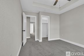 Parkville house for rent - A spacious room with a carpeted floor and a ceiling fan.