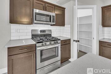 Parkville house for rent - A kitchen with a stove top oven and microwave above it.