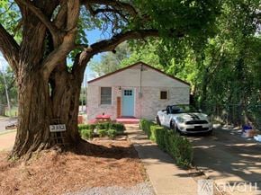 Nashville apartment for rent - A white car is parked in front of a small house with a blue door.
