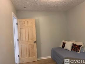 Nashville apartment for rent - A bedroom with a bed and a wooden door.