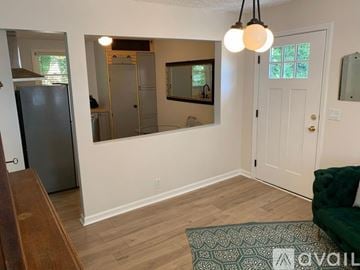 Nashville apartment for rent - A living room with a green couch and a fridge.