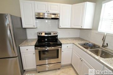 San Antonio house for rent - A kitchen with white cabinets and a stainless steel refrigerator.