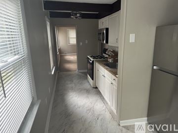 Lindenwold apartment for rent - A kitchen with white cabinets and a marble floor.