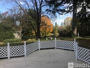 Mount Pleasant house for rent - A wooden deck with a lattice fence and trees in the background.