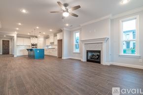 Cave Springs house for rent - A spacious living room with a fireplace and a ceiling fan.
