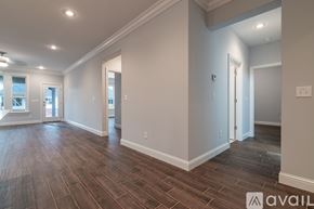 Cave Springs house for rent - A spacious room with wood flooring and white walls.