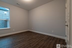 Cave Springs house for rent - A room with wooden flooring and a window overlooking a brick building.