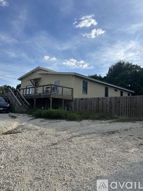 Spring Branch house for rent - A bedroom with a bed, a crib, and a ceiling fan.