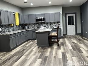 Spring Branch house for rent - A bathroom with grey tiles and a shelf with toiletries.