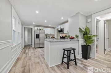 Bristol apartment for rent - A kitchen with white cabinets and a wooden floor.
