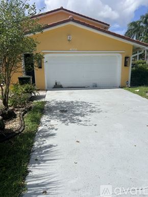 Coconut Creek house for rent - A room with a wooden cabinet, a chair, and a table.