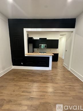 Greenville condo for rent - A kitchen with black cabinets and a wooden floor.