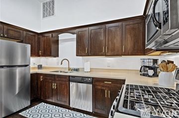 Mobile apartment for rent - A kitchen with a stove top oven and a refrigerator.