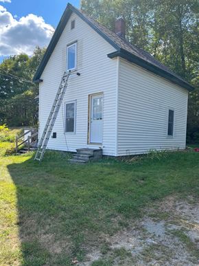 Alton house for rent - A small white house with a ladder in front.