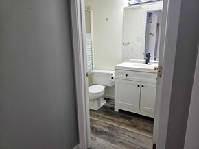 Edmonton apartment for rent - A bathroom with a toilet, sink, and cabinet.