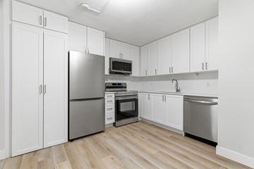 Kitchener apartment for rent - A kitchen with white cabinets and a stainless steel refrigerator.