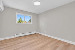 Waterloo apartment for rent - A room with a window showing a view of trees and a wall-mounted air conditioner.