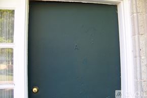 Pekin townhouse for rent - A black door with a gold handle and a white frame.