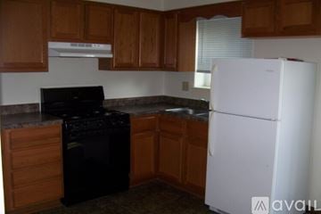 Pekin townhouse for rent - A kitchen with a black stove top oven and a white refrigerator.