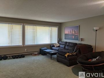 Crookston house for rent - A living room with a black leather couch and a framed picture on the wall.
