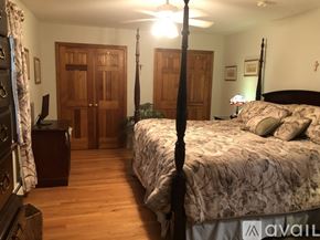 Woodbury house for rent - A bedroom with a four poster bed and a wooden floor.