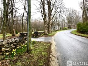 Woodbury house for rent - A rural road with a stone wall and trees on the side.