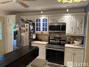 Woodbury house for rent - A kitchen with a refrigerator, oven, and microwave.