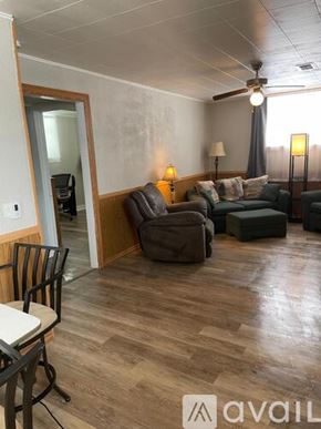 Rawlins apartment for rent - A living room with a brown couch and a wooden floor.