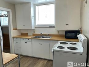 Rawlins apartment for rent - A kitchen with white cabinets and a white stove top oven.