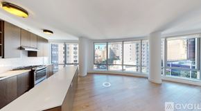 New York apartment for rent - A spacious kitchen with wooden floors and a large island in the middle.
