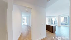 New York apartment for rent - A spacious room with wooden floors and white walls, with a large window on the right side.