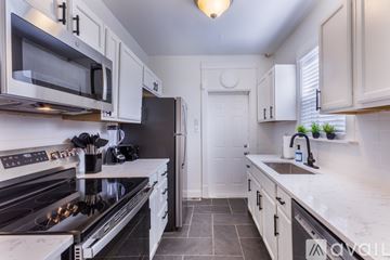 Maplewood house for rent - A kitchen with white cabinets and a black stove top.