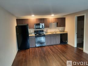 Lowell apartment for rent - A kitchen with black appliances and wooden floors.