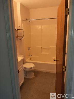 Lowell apartment for rent - A bathroom with a toilet, tub, and towel rack.