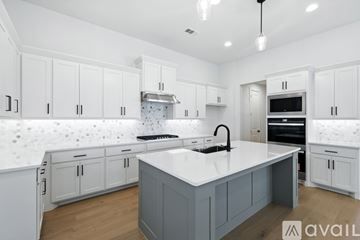 Haslet house for rent - A modern kitchen with white cabinets and a central island.