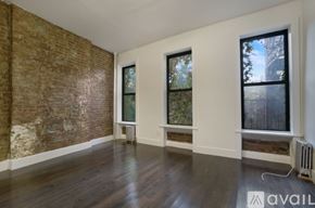 New York apartment for rent - A room with a brick wall and wooden floors.