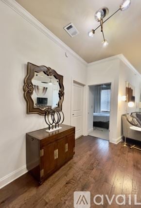 Knoxville condo for rent - A bedroom with a large mirror and wooden floors.
