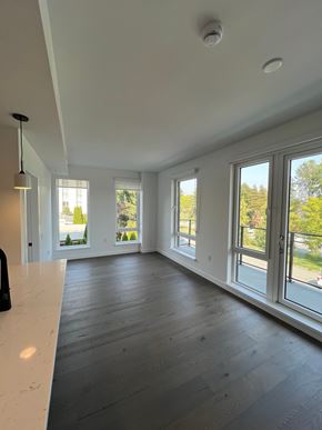 Vancouver apartment for rent - A large, empty room with a white counter and wooden floors.