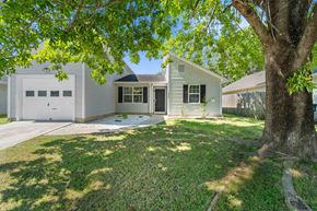 Jacksonville house for rent - A house with a white garage door and a tree in front.