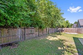 Jacksonville house for rent - A backyard with a wooden fence and green grass.