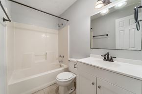 Jacksonville house for rent - A white bathroom with a toilet, sink, and bathtub.